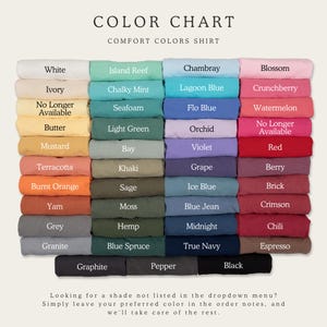 May include: A color chart for Comfort Colors shirts featuring a grid of folded fabric swatches in various shades. Each swatch is labeled with its color name, including White, Ivory, Butter, Mustard, Terracotta, Burnt Orange, Yam, Grey, Granite, Graphite, Island Reef, Chalky Mint, Seafoam, Light Green, Bay, Khaki, Sage, Moss, Hemp, Blue Spruce, Pepper, Chambray, Lagoon Blue, Flo Blue, Orchid, Violet, Grape, Ice Blue, Blue Jean, Midnight, True Navy, Blossom, Crunchberry, Watermelon, Red, Berry, Brick, Crimson, Chili, Espresso, and Black.