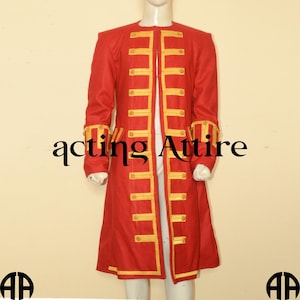 Puede incluir: Un abrigo largo rojo con ribetes dorados y cuello alto. El abrigo tiene un cierre frontal con botones y ribetes dorados en la parte delantera.