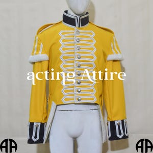 May include: A yellow military-style jacket with white and blue trim. The jacket has a high collar and a row of buttons down the front. The jacket is tailored and has a long tail.