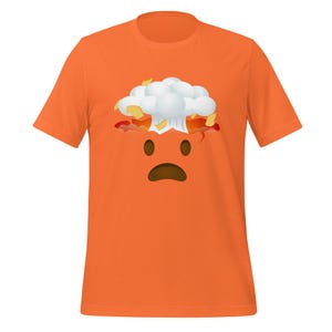 Puede incluir: Camiseta naranja con un gráfico de una cara amarilla con una nube blanca explotando desde la parte superior de su cabeza.