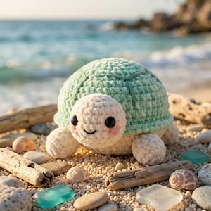 May include: A crocheted turtle plush toy featuring a soft, pale green shell and a cream-colored head and limbs. The turtle has two round black eyes, a small stitched smile, and light pink blush marks on its cheeks, crafted from yarn.