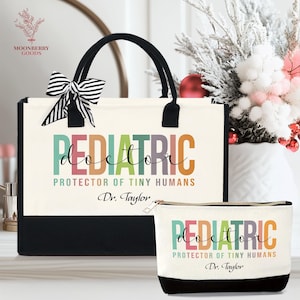 May include: A canvas tote bag and matching cosmetic bag. The bags are off-white with black bottoms and handles. The text "PEDIATRIC doctor PROTECTOR OF TINY HUMANS Dr. Taylor" is printed on both bags in colorful letters. A black and white striped bow adorns the tote bag.