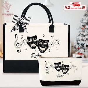 May include: A white tote bag and matching cosmetic bag with black accents. Both bags feature a musical note design with comedy and tragedy masks and the name "Taylor". The tote bag has a black and white striped bow.