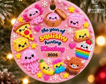 May include: A round pink 3D relief ornament featuring various cute food and animal characters, including an axolotl, a dumpling, a slice of pizza, a banana, and a highland cow. The text reads "the year of Squishy hunting Kinsley 2026".