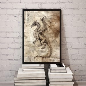 May include: Framed artwork showing a detailed sketch of a dragon with outstretched wings. The dragon is in shades of brown and grey against a parchment-like background with handwritten script. The artwork is displayed in a black frame.