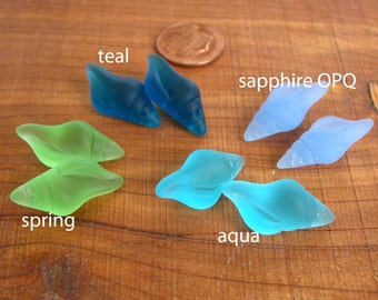 May include: Assortment of six glass sea shell beads in teal, spring green, aqua, and sapphire blue colors.