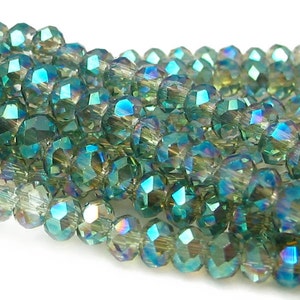 May include: A strand of iridescent green faceted glass beads. The beads are round and have a shimmering, multi-colored effect.