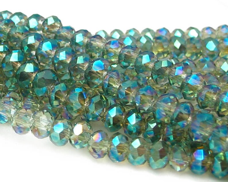May include: A strand of iridescent green faceted glass beads. The beads are round and have a shimmering, multi-colored effect.