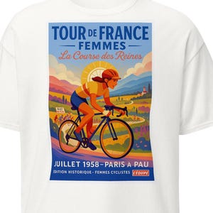 May include: White t-shirt featuring a vintage poster design for the Tour de France Femmes cycling race. The poster depicts a cyclist in action, with text in French. The design includes a vibrant landscape with mountains and a sun.