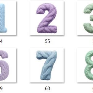 Op de afbeelding: Een verzameling van tien gebreide cijfers, elk in een andere pastelkleur. De cijfers, van 0 tot en met 9, hebben een textuur met kabelbreisel. Elk cijfer wordt weergegeven op een witte achtergrond.