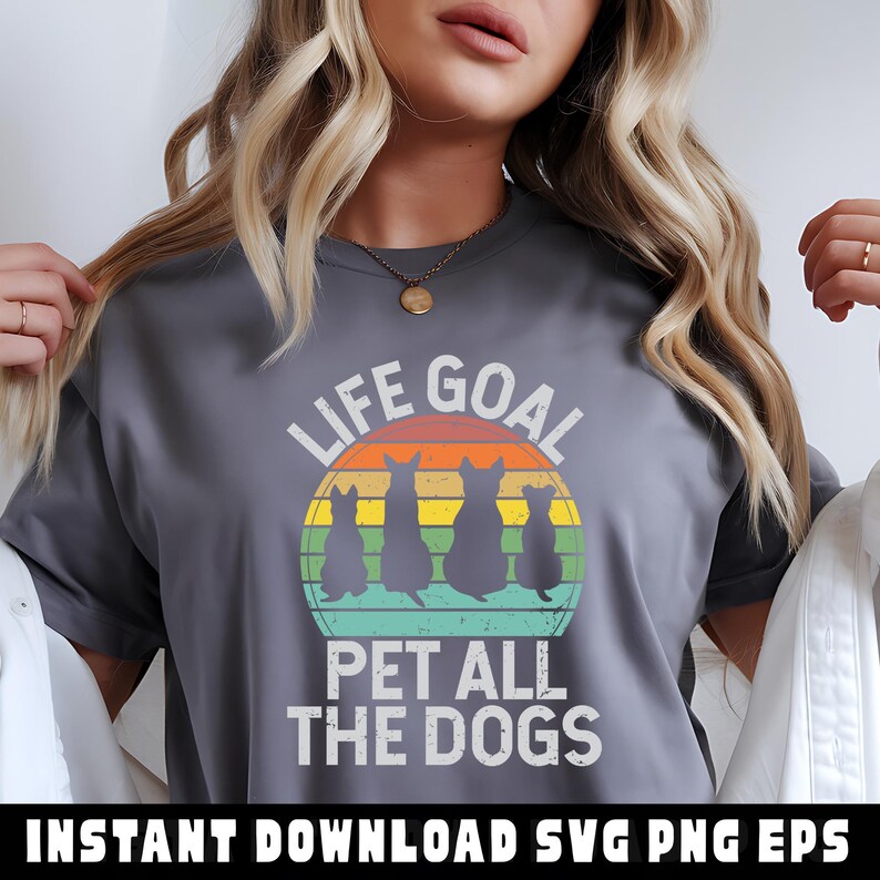 May include: Gray t-shirt with the text "LIFE GOAL" above a retro-style graphic of four dog silhouettes against a sunset. Below the graphic, the text reads "PET ALL THE DOGS".