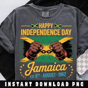 以下が含まれることがあります： ジャマイカ独立記念日を祝うグラフィックがプリントされたダークグレーのTシャツ。ジャマイカの国旗、鎖を壊す2つの拳、そして「Happy Independence Day Jamaica Est 6th August 1962」の文字がデザインされています。