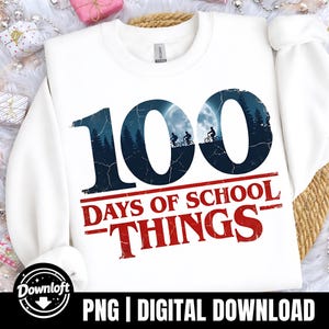 May include: White sweatshirt with the text "100 DAYS OF SCHOOL THINGS" in red and navy blue. The numbers "100" feature a silhouette of cyclists against a forest and moon backdrop. A digital download graphic.