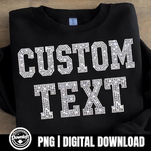 May include: Black sweatshirt featuring the words "CUSTOM TEXT" in large, sparkling, rhinestone-style letters. The design is centered on the front of the garment. The bottom of the image includes the text "PNG | DIGITAL DOWNLOAD".
