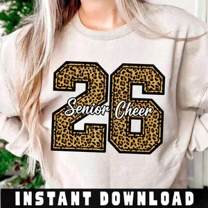 Op de afbeelding: Een beige sweatshirt met een luipaardprint "26" ontwerp en de woorden "Senior Cheer" in witte letters. De sweatshirt heeft een ronde hals en lange mouwen. De onderkant van de afbeelding luidt "INSTANT DOWNLOAD".