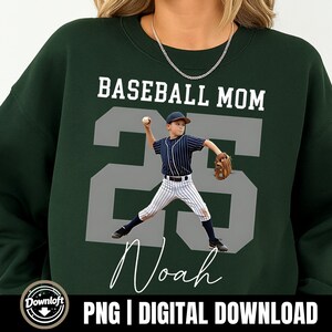May include: Dark green sweatshirt with the text "BASEBALL MOM" above a large grey number "25". A graphic of a baseball player is in the centre. The name "Noah" is written in cursive below the number. The bottom of the sweatshirt has the text "PNG | DIGITAL DOWNLOAD".