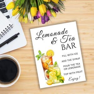 May include: A white sign with the words "Lemonade & Tea BAR" in black script. The sign features illustrations of iced tea and lemonade, with instructions: "Fill with ice, add the syrup, pour the tea or lemonade, top with fruit, enjoy!"