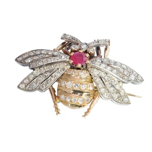Broche de abeja del período de entreguerras con diamantes y rubíes en oro y plata.