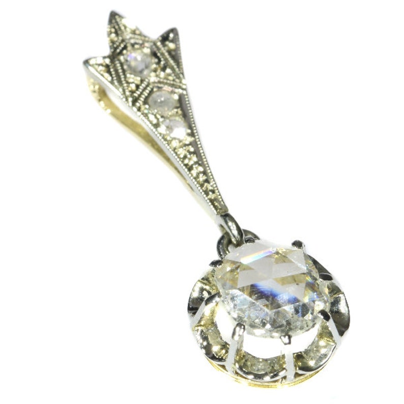 May include: A silver pendant with a large, clear, faceted gemstone surrounded by smaller diamonds. The pendant is attached to a delicate silver chain with a star-shaped design.