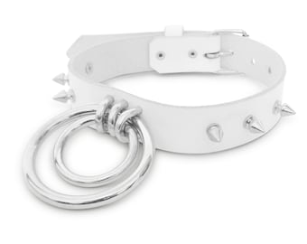 May include: White leather choker with silver spikes and a double ring pendant.