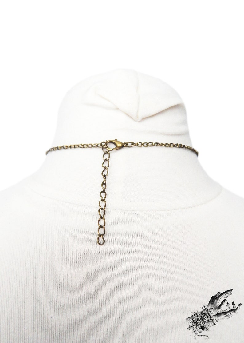 Back of the antique bronze Steampunk gear necklace, showing the adjustable lobster clasp fastening and extender chain for versatile sizing and comfort. Suspended on a white mannequin bust, this statement necklace highlights its intricate links and Steampunk design. This handmade necklace showcases a vintage industrial aesthetic, perfect for steampunk enthusiasts and mechanical-inspired fashion lovers.