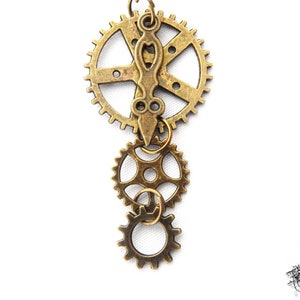 Close-up of Steampunk gear earrings featuring intricately detailed bronze-tone gears and cogs. These handmade dangle earrings showcase a vintage industrial aesthetic, perfect for steampunk enthusiasts and mechanical-inspired fashion lovers. Lightweight design ensures comfort, while interlocking gears add depth and movement. Ideal for cosplay, themed events, or unique statement accessories. A great gift for fans of quirky, alternative jewelry styles.