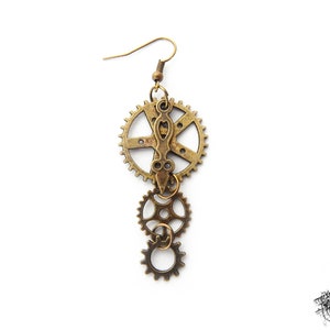 Steampunk gear earrings featuring intricately detailed bronze-tone gears and cogs. These handmade dangle earrings showcase a vintage industrial aesthetic, perfect for steampunk enthusiasts and mechanical-inspired fashion lovers. Lightweight design with earring hooks ensures comfort, while interlocking gears add depth and movement. Ideal for cosplay, themed events, or unique statement accessories. A great gift for fans of quirky, alternative jewelry styles.