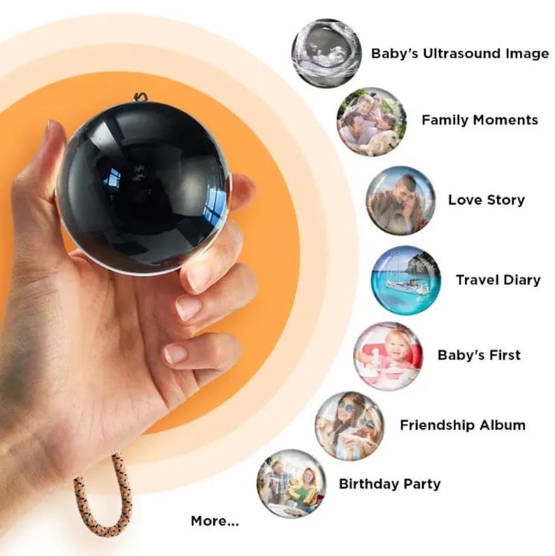 May include: A black sphere with a shiny surface is held in a hand, suspended by a decorative cord. The sphere is surrounded by images labeled "Baby's Ultrasound Image," "Family Moments," "Love Story," and other memories.