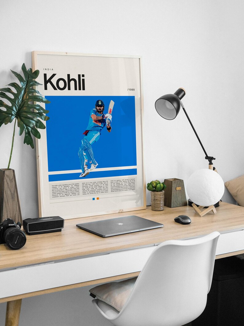 Pu&ograve; includere: Un poster incorniciato con uno sfondo blu che presenta una foto di un uomo con una divisa blu e bianca che gioca a cricket. Il poster ha il testo "INDIA Kohli /1988" nella parte superiore.