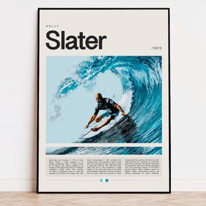 May include: A framed poster featuring surfer Kelly Slater. The poster has a cream background with the name "Slater" in large black letters. A photo shows Slater surfing a large blue wave. Text at the bottom details his career.