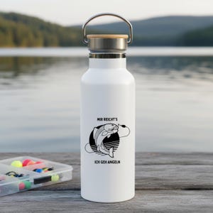 Könnte beinhalten: Weiße isolierte Wasserflasche mit silbernem Griff und Bambusdeckel. Die Flasche hat eine schwarz-weiße Grafik eines Fisches mit dem Text "MIR REICHT'S ICH GEH ANGELN".