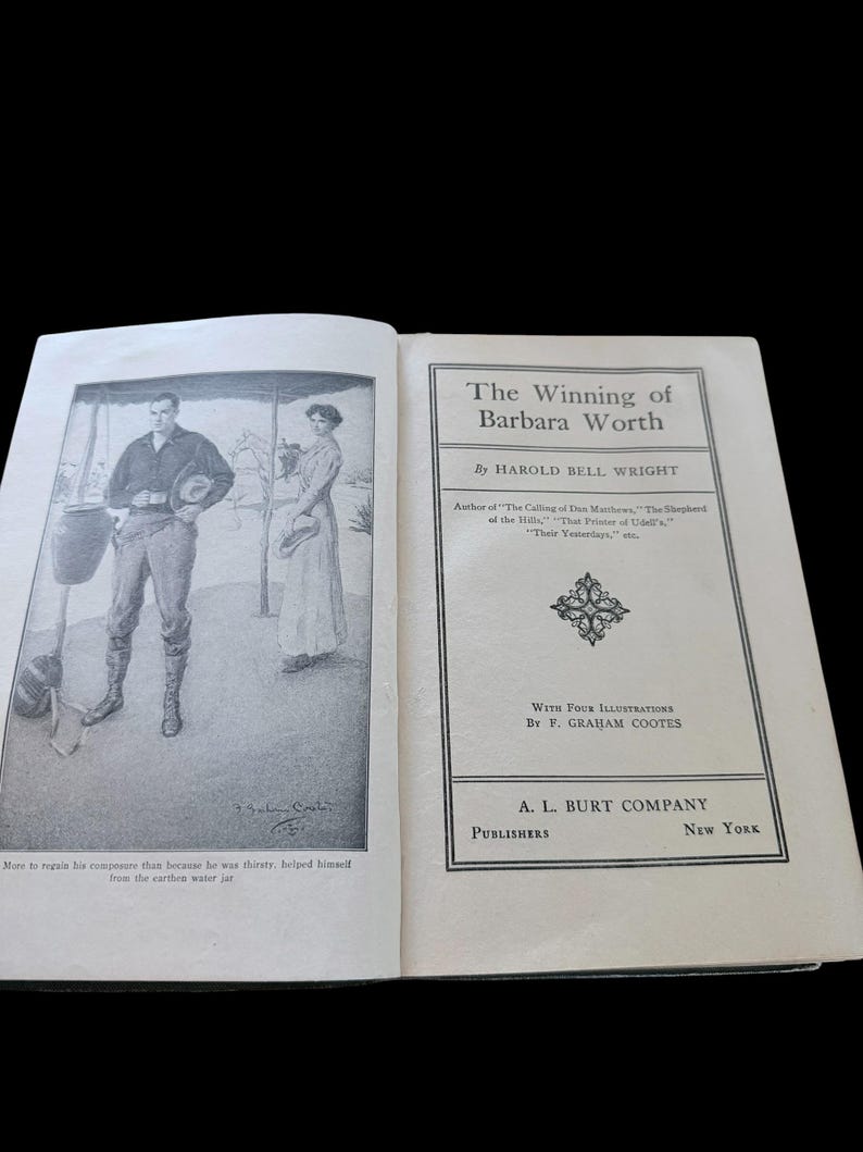 May include: An open book titled The Winning of Barbara Worth by Harold Bell Wright, published by A. L. Burt Company. The left page features a black and white illustration of a person standing near a water jar, with text below the image.