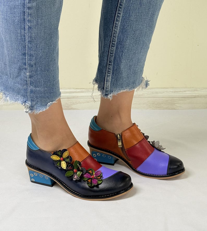 Puede incluir: Zapatos de cuero multicolores con una cremallera lateral y adornos florales. Los zapatos tienen un tac&oacute;n de bloque y una puntera redonda.