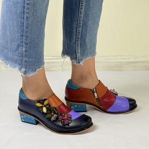 Puede incluir: Zapatos de cuero multicolores con un dise&ntilde;o floral en la punta. Los zapatos tienen un tac&oacute;n grueso y una cremallera en el lateral.