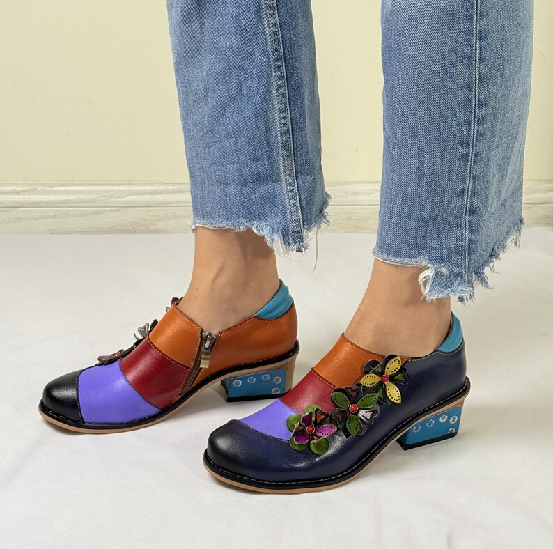 Puede incluir: Zapatos de cuero multicolores con un esquema de colores azul, morado, rojo y naranja. Los zapatos tienen un peque&ntilde;o adorno floral en la punta y una cremallera en el lateral. Los zapatos tienen un tac&oacute;n de bloque.