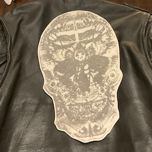 May include: A black leather jacket with a white moth skull patch on the back.