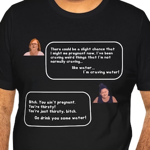 Może przedstawiać: Czarna koszulka z białym tekstem i obrazkami. Tekst zawiera zwroty takie jak "Mam ochotę na wodę!" i "Idź się napić wody!" Koszulka zawiera dwa obrazy kobiet w dymkach.