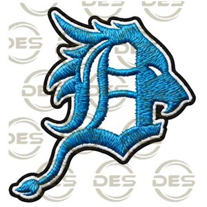 Puede incluir: Parche bordado con una letra "D" azul claro estilizada, integrada en un diseño de cabeza de león. El parche tiene un borde negro y un reverso blanco. El diseño está detallado con costuras texturizadas. Adecuado para ropa o accesorios.