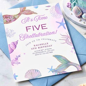 Puede incluir: Una invitación de cumpleaños con temática de sirenas con un sobre azul claro. La invitación presenta el texto "It's Time FIVE Shellabration!" con ilustraciones de colas de sirenas y conchas marinas. La invitación incluye los detalles del cumpleaños.