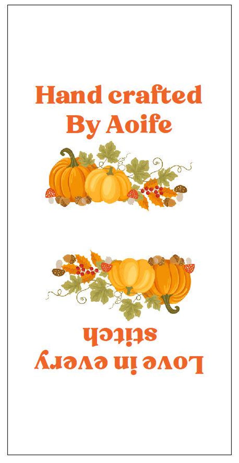 Op de afbeelding: Een wit rechthoekig stoffen label met de oranje tekst Hand crafted By Aoife bovenaan en Love in every stitch onderaan. Tussen de tekst staan twee illustraties van oranje pompoenen, groene bladeren, eikels en rode bessen.