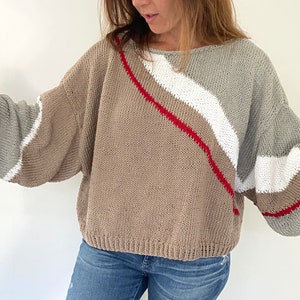 May include: A brown, gray, white, and red striped knit sweater with a relaxed fit.