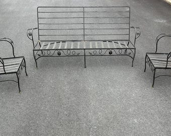 May include: A three-piece outdoor patio set in a dark gray metal finish. The set includes a loveseat and two armchairs. The seats and backs are constructed with horizontal metal slats. The loveseat has decorative scrollwork on the front.