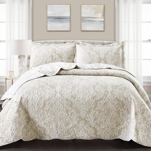 May include: A beige and white damask patterned quilt set with two matching pillowcases. The quilt is made of soft, comfortable fabric and features a subtle, elegant design.