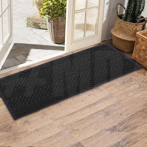 May include: A black doormat with a herringbone pattern. The doormat is made of a durable material and is designed to trap dirt and moisture.