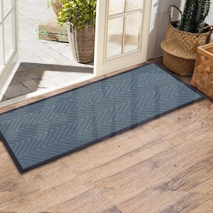 May include: A gray doormat with a herringbone pattern. The doormat is placed in front of a wooden door with a glass panel.