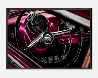 May include: Close-up of a vintage car's interior, featuring a bright pink dashboard and a black steering wheel. The steering wheel has a chrome centre and a silver key chain hanging from it. The dashboard has a round gauge with the text "Miles Low Press" visible.