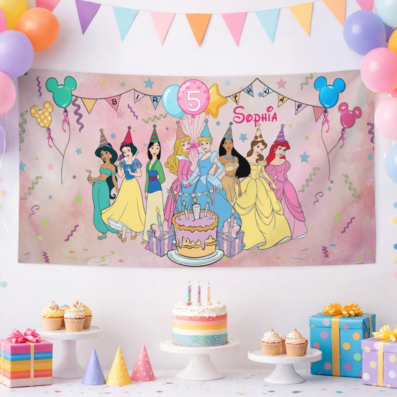 May include: A rectangular birthday banner featuring a pink watercolor background with illustrations of eight Disney princesses, a tiered cake, and the text '5' and 'Sophia'. The banner is decorated with colorful balloons, stars, and streamers.