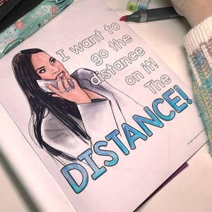 May include: A coloring book page with a woman on the phone, with the text "I want to go the distance on it! The DISTANCE!" in blue and white. The image is partially colored with markers.