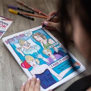 May include: A colourful comic book illustration with the words "NEW YORK" and speech bubbles. The artwork features drawings of people and the phrases "Please don't let it be about Tom" and "I MADE IT NICE!"