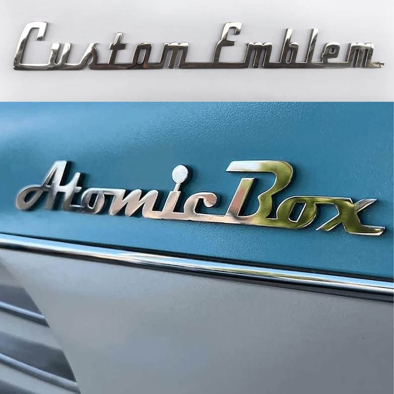 May include: A silver metal emblem with the text "Custom Emblem" and a second silver metal emblem with the text "Atomic Box".